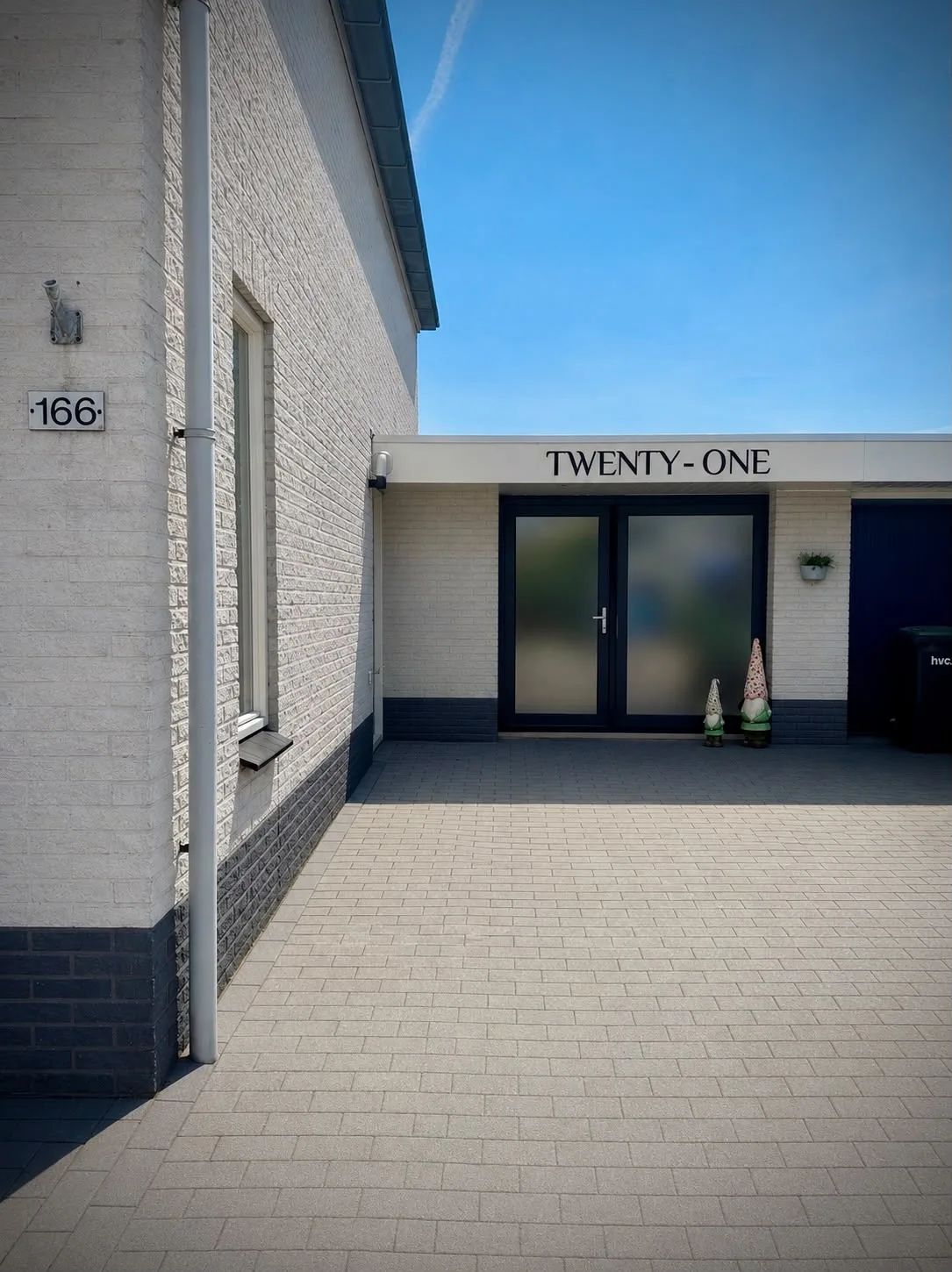 De gevel van Twenty-One op huisnummer 166 in Hoorn, met het bestrate pad voor de deur